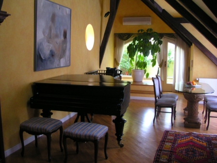 a room with a piano and chairs
