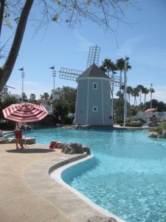 a pool with a windmill and palm trees