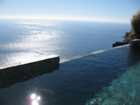 a pool with a stone ledge over the water