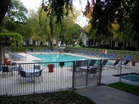 a pool with chairs and a fence
