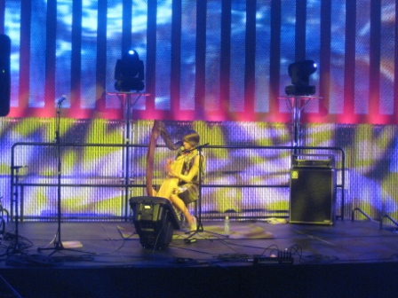 a woman playing a guitar on a stage