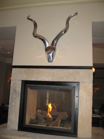 a fireplace with a silver sculpture of a horn