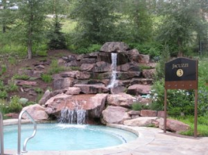 a pool with a waterfall and a sign