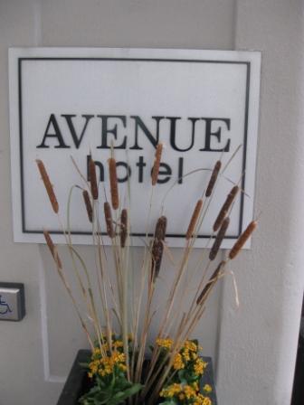 a sign with a plant in front of a hotel