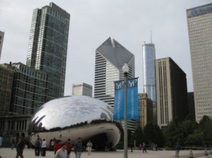 a group of people walking in front of a large reflective object