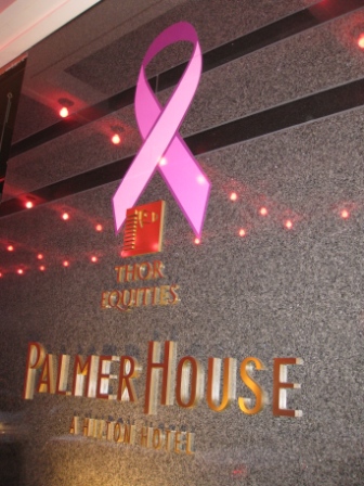 a pink ribbon on a grey wall