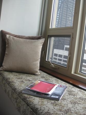 a pillow and magazines on a window sill