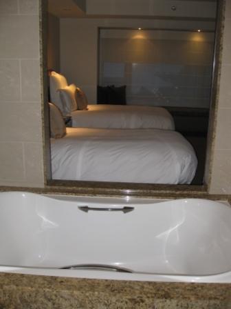 a mirror with a bed and a bathtub