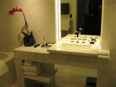 a bathroom sink with a mirror and a flower