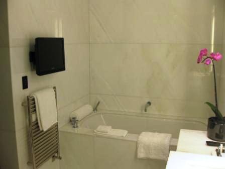 a bathroom with a bathtub and a tv