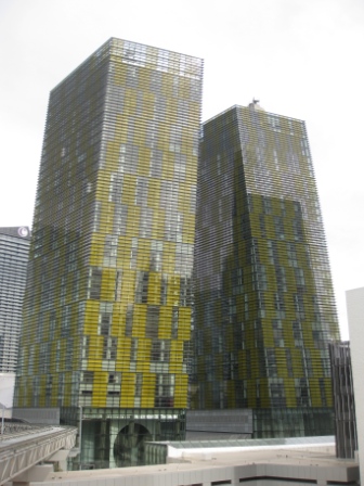 a tall building with yellow walls with Veer Towers in the background
