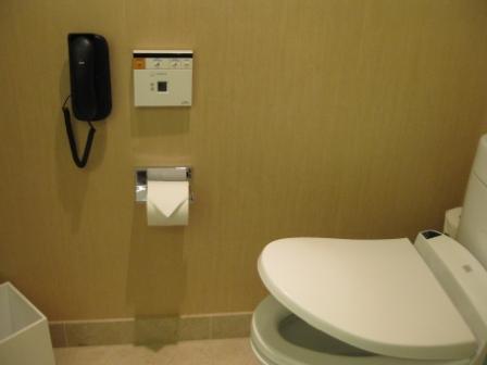 a toilet with a phone and a paper roll