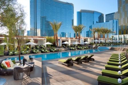 a pool with lounge chairs and umbrellas with Mandarin Oriental, Las Vegas in the background