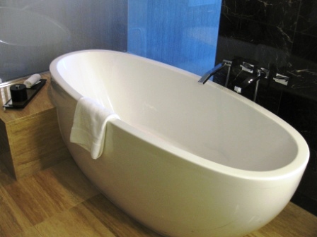 a white bathtub with a towel on the side