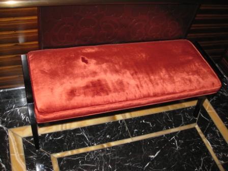 a red bench with black and white marble floor