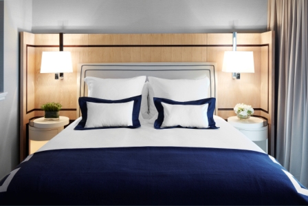 a bed with white pillows and blue blanket