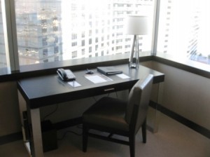 a desk with a telephone and a lamp