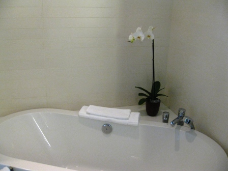 a white bathtub with a flower on the side