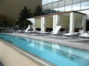 a pool with lounge chairs and a building