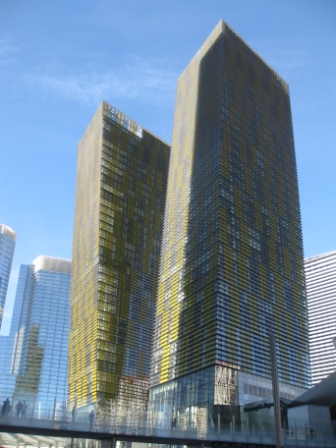 a tall buildings with yellow and white windows with Veer Towers in the background