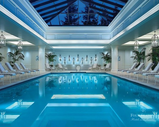 a swimming pool with chairs and a skylight