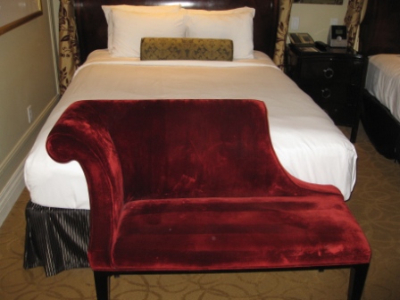 a red chair next to a bed