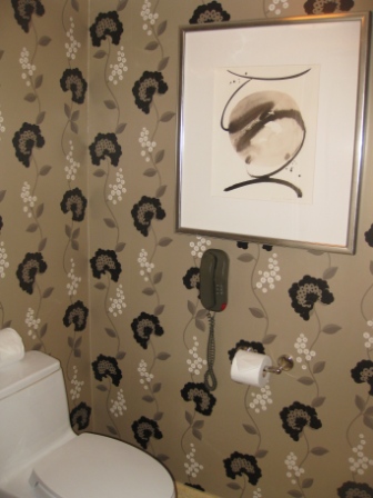 a bathroom with a phone and a picture on the wall
