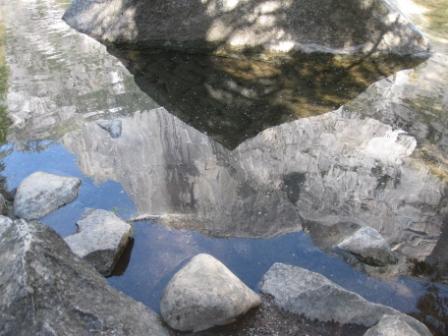 a reflection of a mountain in a pond