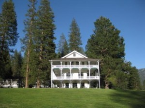 a large white house with trees in the background