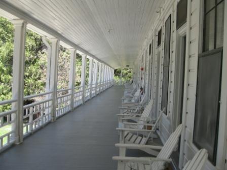 a long porch with white chairs