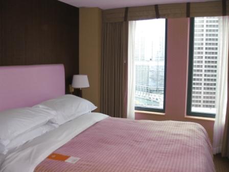 a bed with pink bedding and a lamp