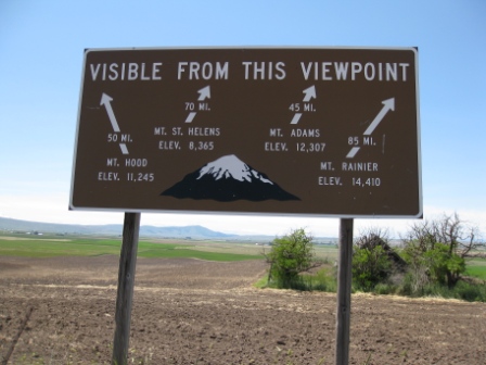a sign with a mountain in the background