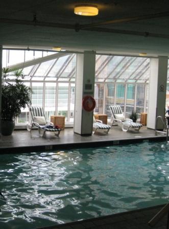 a swimming pool with chairs and a large window