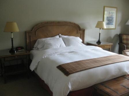 a bed with white sheets and pillows