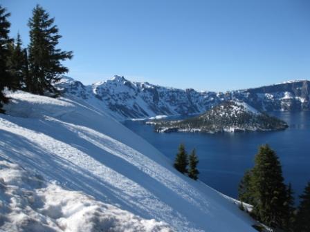 a snowy mountain with a lake in the background