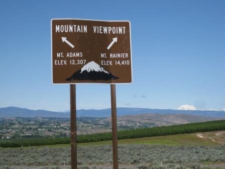 a sign with mountains in the background