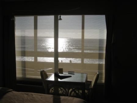 a table and chairs in a room with a view of the ocean