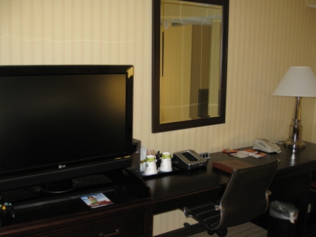 a desk with a television and a mirror