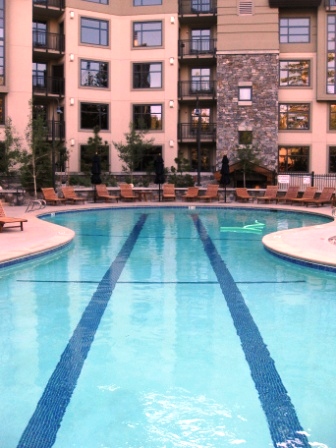 a swimming pool with chairs and a stone building