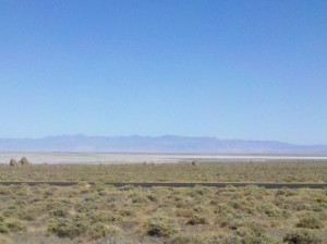 a landscape with a road and mountains in the background