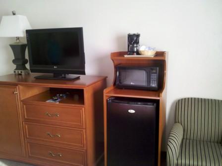 a tv and microwave on a small refrigerator