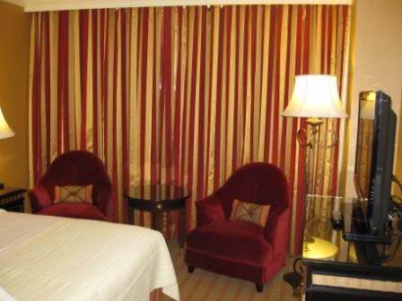 a hotel room with red and gold curtains