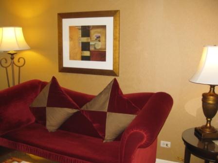 a red couch with pillows and a lamp