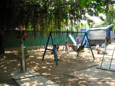 a group of kids playing on a swing set
