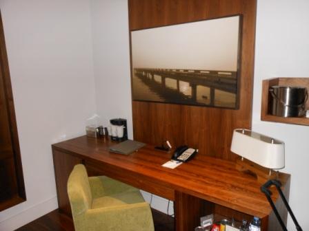 a desk with a chair and a picture on the wall