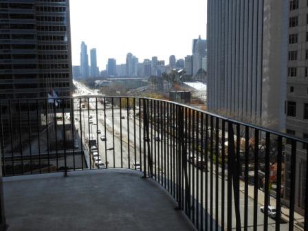 a balcony with a railing and a city in the background