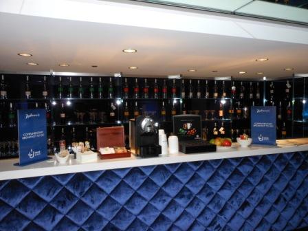 a bar with a blue wall and bottles of liquor