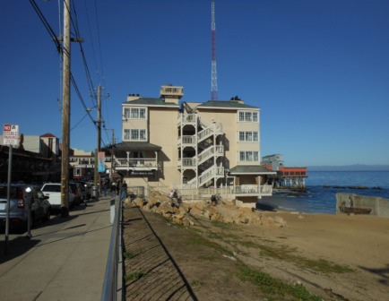 a building with a spiral staircase on the side of the beach