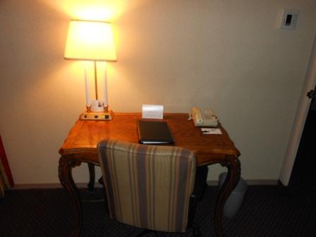 a desk with a lamp and a phone
