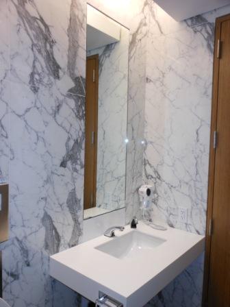 a bathroom with marble walls and a mirror